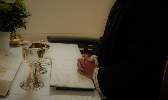 Billede af præst der beder ved alteret